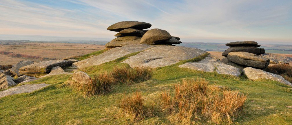 Flat stone cairns atop a hill in the Cornish countryside.