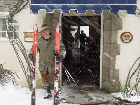 Toby Ashworth stood outside The Nare in the snow with his skis in hand