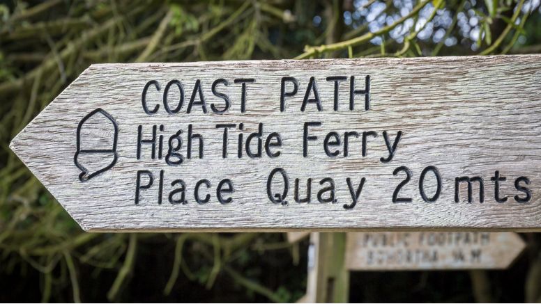 A wooden coast path sign.