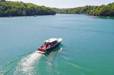 A boat sails down the River Fal.