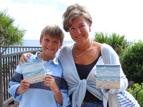 A woman and child proudly show the paintings they've created on their painting holiday in Cornwall.