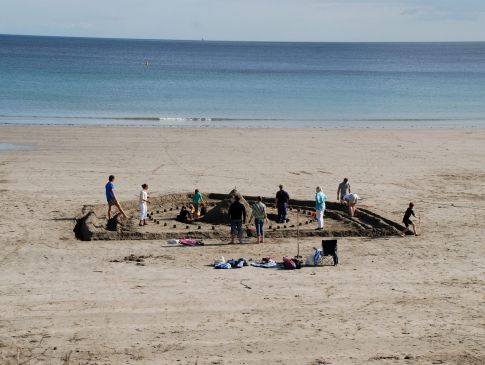 A family builds a giant sandcastle on Carne Beach.