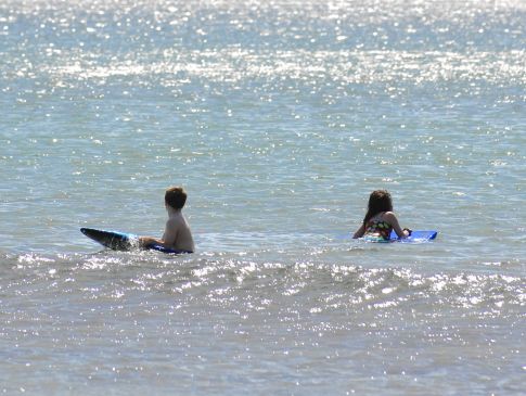 Children play in the sea at Carne Bay Beach on the Roseland near St Mawes.