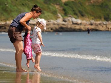 A mother and her two children play on Carne Beach on the south coast of Cornwall.