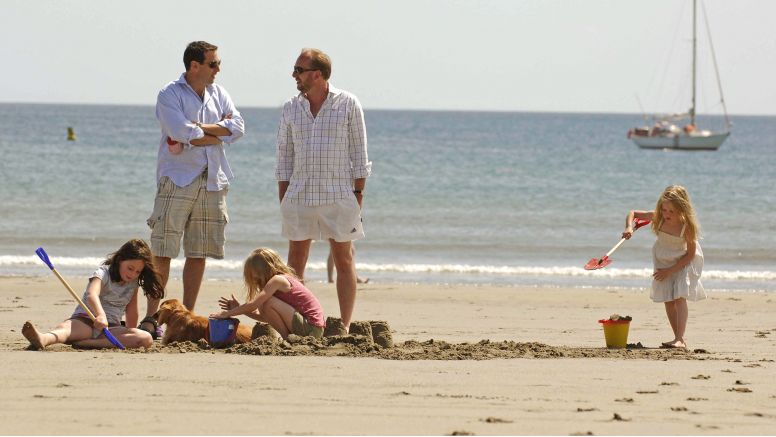 Holidaymakers enjoy the sun and sand at Carne Beach, the best beach on the south Cornish coast.