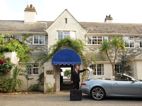 Outside The Nare hotel, the concierge unloads a guest's bags from the hotel courtesy car.