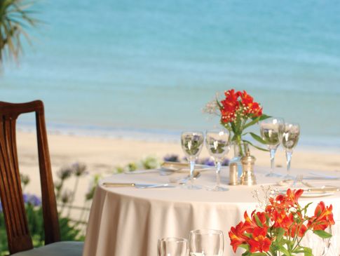 A table set in The Nare hotel's dining room, with views of the Cornish coast.