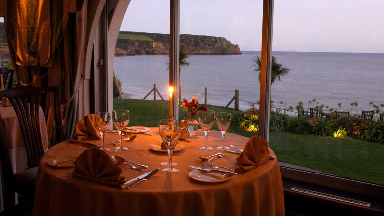 A candlelit table at dusk in The Nare hotel's dining room.