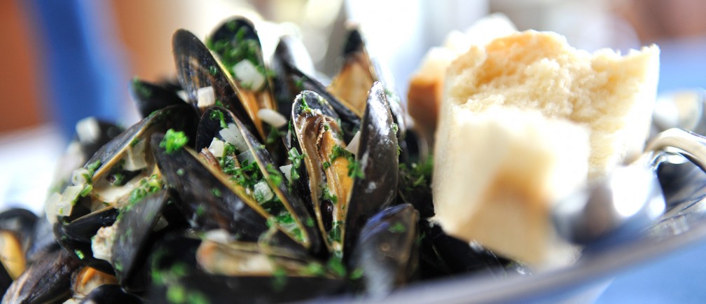 A plate of fresh mussels and crusty bread.