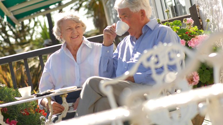 A couple of guests sip coffee on the patio at The Nare hotel.