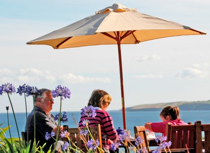 A family sits beneath a parasol at The Nare hotel.