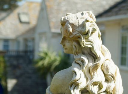 A statue of a lady in The Nare hotel gardens.