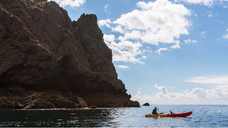 A teenage boy out on the water in a canoe by Nare Head