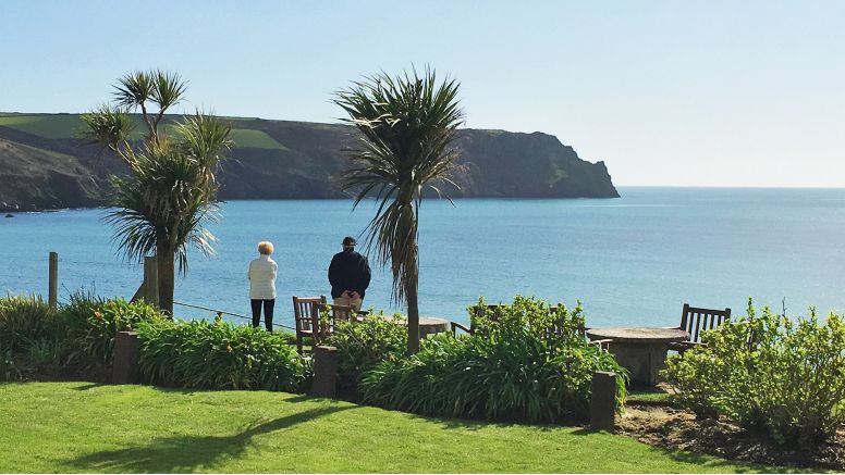 A couple enjoying the stunning sea views from the gardens at The Nare, Cornwall's 5 star country house hotel