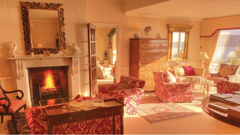 The drawing room at The Nare, with a fire blazing in the hearth.