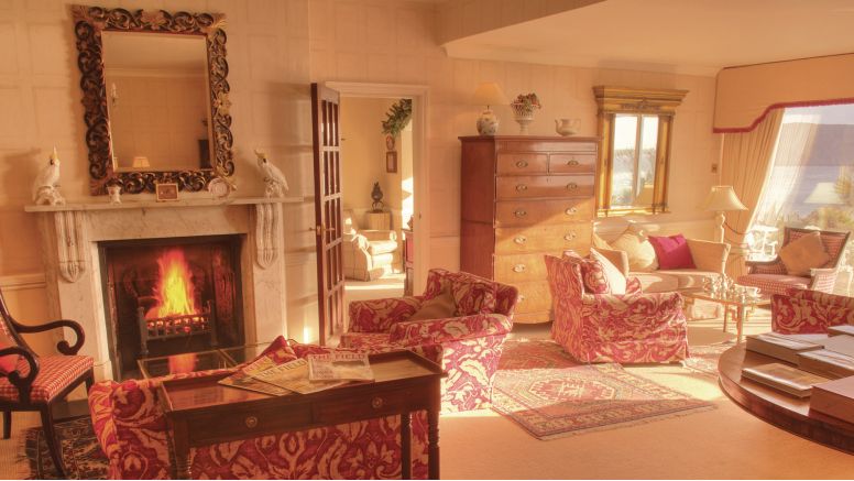 The drawing room at The Nare, with a fire blazing in the fireplace.