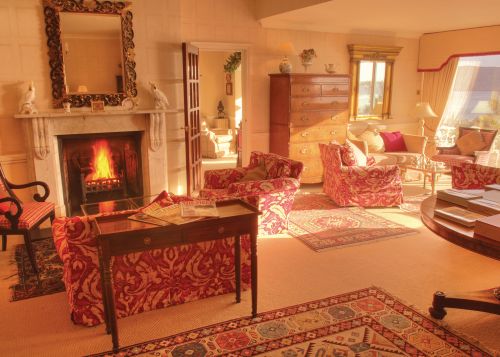 The lounge at The Nare hotel, with a fire roaring in the fireplace.