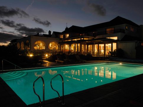 The Nare hotel and swimming pool by night.