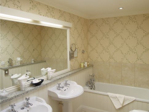 A hotel bathroom with double sinks.