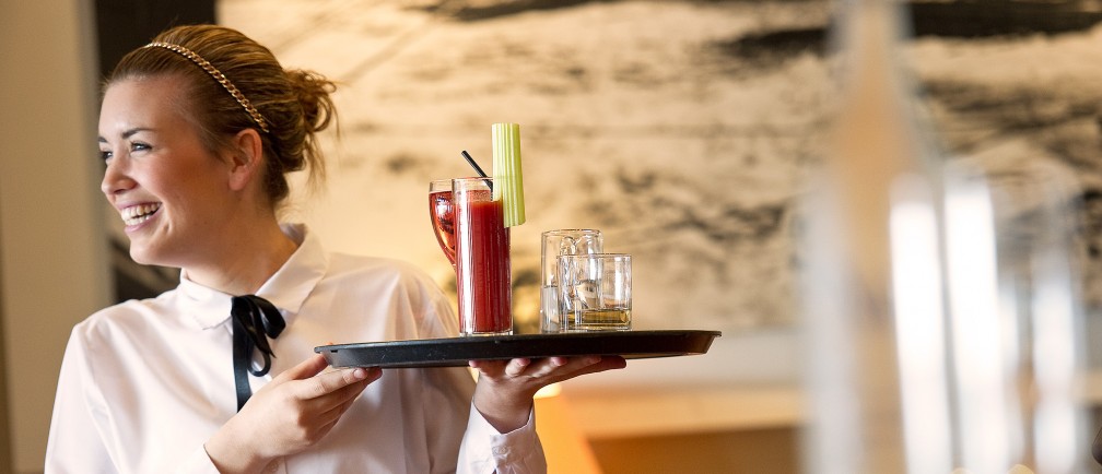 A waitress at The Nare holds a tray of drinks.