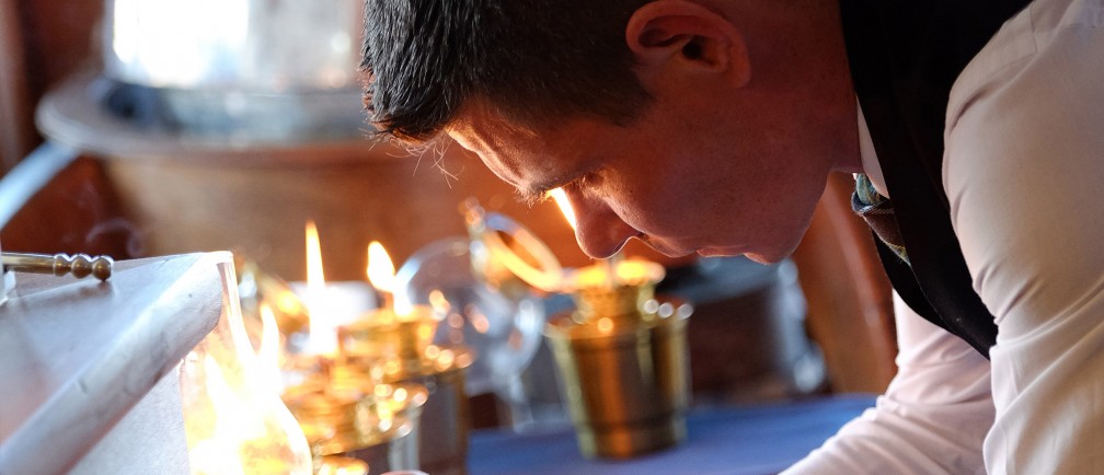 A team member at The Nare lights candles.