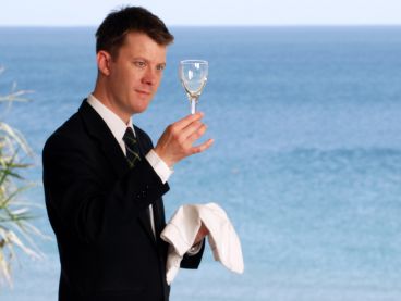 The Nare hotel's Restaurant manager inspects a wine glass.