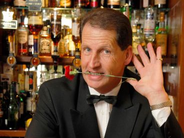 The Head Barman at The Nare hotel with a rose in his teeth.