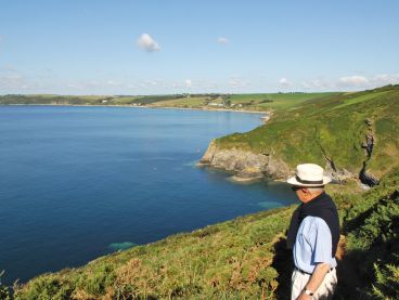 A man looks back at the hotel from the coast path