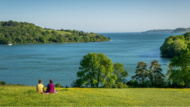 Two people sat taking in the view of the Fal River estuary